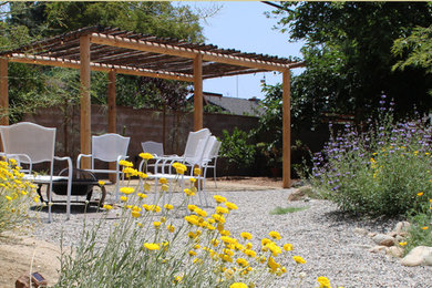 Ejemplo de jardín de secano clásico de tamaño medio en verano en patio trasero con exposición total al sol y adoquines de piedra natural