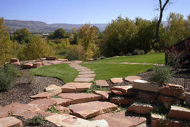 Inspiration for a mid-sized traditional drought-tolerant backyard stone landscaping in Salt Lake City.