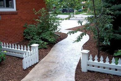 Idée de décoration pour un aménagement d'entrée ou allée de jardin latéral tradition avec des pavés en béton.