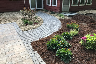 This is an example of a mid-sized traditional drought-tolerant and full sun backyard concrete paver landscaping in Boston.