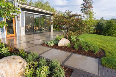 Foto de jardín clásico renovado de tamaño medio en patio trasero con exposición total al sol y adoquines de hormigón