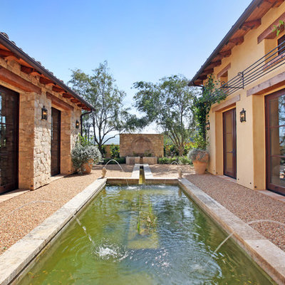 Design ideas for a large mediterranean partial sun courtyard gravel water fountain landscape in Los Angeles.