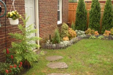 Photo of a mid-sized modern shade backyard concrete paver landscaping in New York for summer.