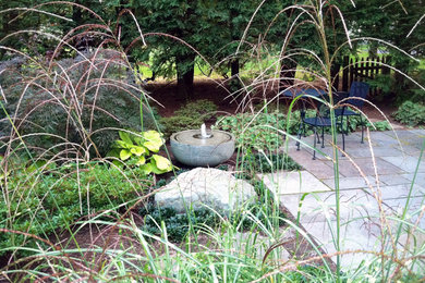 Ejemplo de jardín de estilo zen en patio trasero con jardín francés, fuente, exposición parcial al sol y adoquines de piedra natural