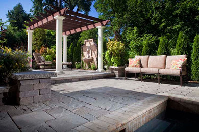 Example of a large stone patio design in Minneapolis