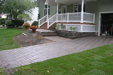 This is an example of a large traditional full sun front yard concrete paver driveway in New York.