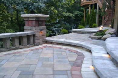 Photo of a large traditional shade backyard stone landscaping in Cleveland with a fire pit.