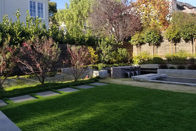 Design ideas for a large modern partial sun backyard retaining wall landscape in San Francisco with decking.