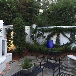 Mittelgroßer Klassischer Garten hinter dem Haus mit Kamin und Betonplatten in New Orleans