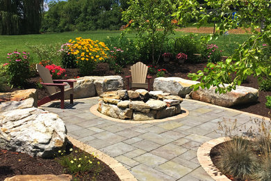 Inspiration for a mid-sized craftsman backyard concrete paver landscaping in Other with a fire pit.