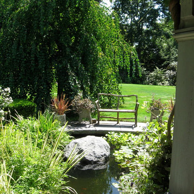 Design ideas for a large traditional partial sun backyard stone landscaping in Boston for summer.