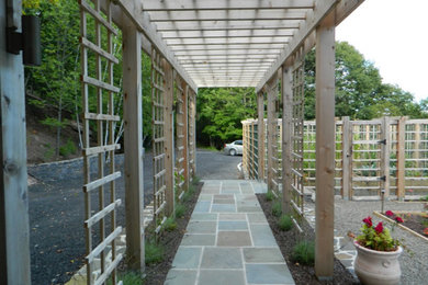 Foto de camino de jardín clásico de tamaño medio en primavera en patio trasero con jardín francés, exposición parcial al sol y adoquines de piedra natural