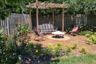 Design ideas for a mid-sized rustic full sun backyard mulch formal garden in Jacksonville with a fire pit for summer.