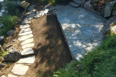 Design ideas for a mid-sized traditional backyard stone landscaping.