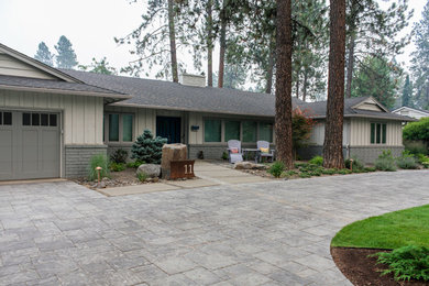 This is an example of a large mid-century modern front yard concrete paver driveway in Other.