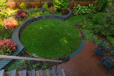 Design ideas for a mid-sized traditional partial sun backyard stone landscaping in Burlington for summer.