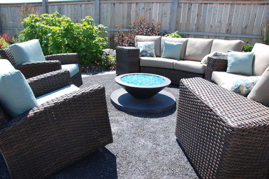This is an example of a mid-sized transitional full sun backyard landscaping in Calgary with a fire pit and decking for summer.
