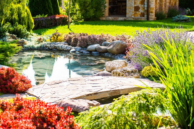 Cette photo montre un jardin à la française arrière chic de taille moyenne et au printemps avec un bassin, une exposition partiellement ombragée et des pavés en pierre naturelle.