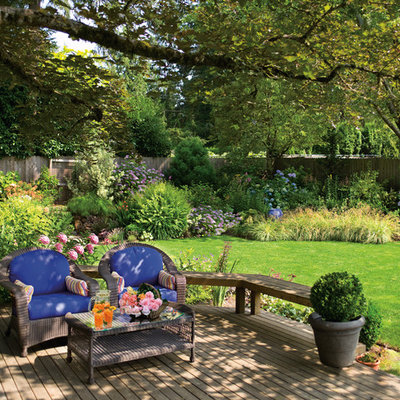 This is an example of a large traditional partial sun backyard formal garden in Portland with decking.