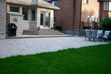 This is an example of a mid-sized partial sun backyard concrete paver landscaping in Montreal.