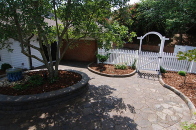 Photo of a small traditional partial sun backyard concrete paver landscaping in Charlotte.