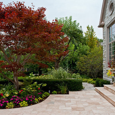 Inspiration for a traditional front yard stone flower bed in Toronto.
