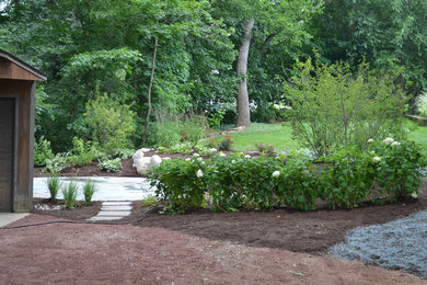 Modelo de jardín rústico de tamaño medio en patio trasero con adoquines de piedra natural