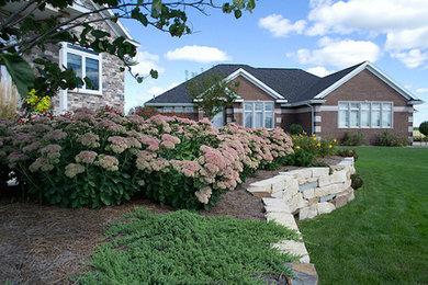 Foto de jardín clásico de tamaño medio en patio trasero con jardín francés, exposición reducida al sol y adoquines de piedra natural