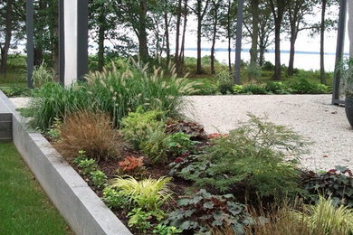 Photo of a large contemporary partial sun courtyard gravel landscaping in Providence for fall.