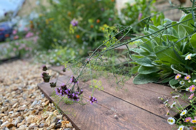 На фото: регулярный сад на боковом дворе в стиле кантри с клумбами
