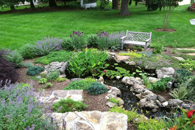 Aménagement d'un jardin classique avec une pente, une colline ou un talus et un bassin.
