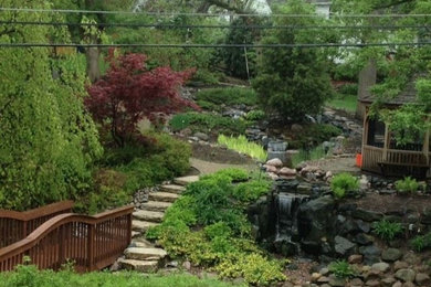 Inspiration for a medium sized rustic sloped fully shaded garden for summer in Chicago with a water feature and natural stone paving.