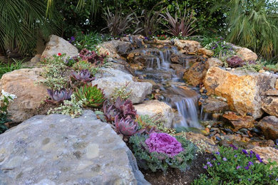 Inspiration for a mid-sized traditional backyard stone water fountain landscape in Los Angeles.
