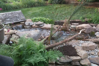 Photo of a mid-sized rustic full sun backyard mulch water fountain landscape in Other for summer.
