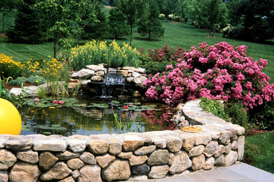 Inspiration for a large traditional partial sun backyard stone landscaping in New York.