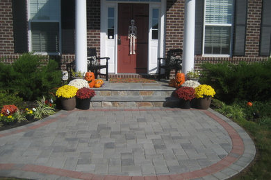 This is an example of a medium sized traditional front garden in DC Metro with a garden path and brick paving.