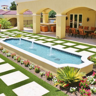 This is an example of a mid-sized mediterranean full sun backyard concrete paver water fountain landscape in Phoenix.