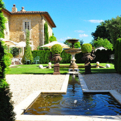 Inspiration for a large mediterranean partial sun backyard gravel landscaping in New York for summer.