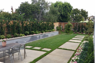 Photo of a large modern back full sun garden in Orange County with concrete paving.
