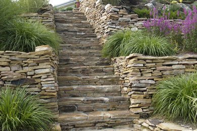 Idées déco pour un jardin arrière classique de taille moyenne et l'été avec une exposition ensoleillée et des pavés en pierre naturelle.