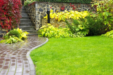 Cette image montre un jardin en pots arrière de taille moyenne avec une exposition partiellement ombragée et des pavés en pierre naturelle.