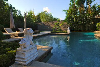 Imagen de piscina con fuente tradicional de tamaño medio en patio trasero con adoquines de hormigón