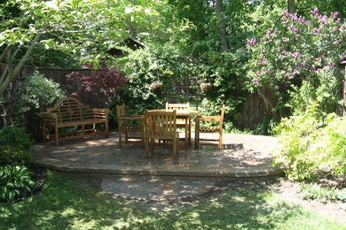Modelo de jardín clásico renovado de tamaño medio en primavera en patio trasero con jardín francés, exposición reducida al sol y adoquines de piedra natural