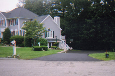 This is an example of a medium sized front driveway garden in Boston with concrete paving.