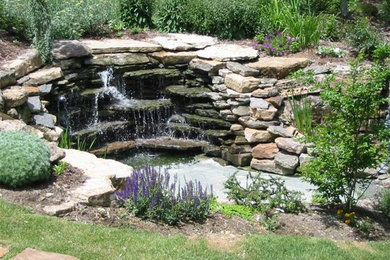 Modelo de jardín de tamaño medio en patio trasero con fuente, exposición total al sol y adoquines de piedra natural