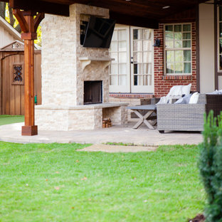 Halbschattiger Klassischer Garten hinter dem Haus mit Kamin, Natursteinplatten und Holzzaun in Dallas