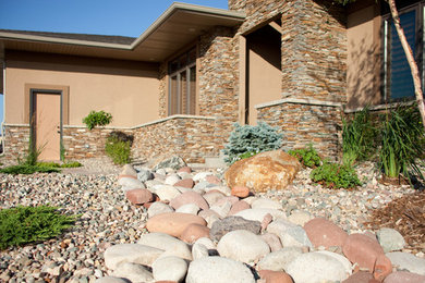 Photo of a large transitional full sun front yard stone retaining wall landscape in Other.