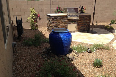 This is an example of a mid-sized partial sun backyard stone landscaping in Phoenix with a fire pit.