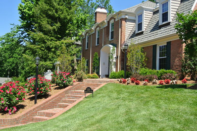 This is an example of a mid-sized traditional full sun front yard brick landscaping in DC Metro.