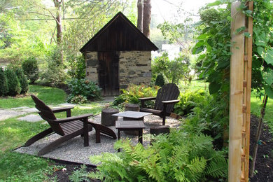 Aménagement d'un petit jardin arrière montagne au printemps avec un foyer extérieur, une exposition ensoleillée et du gravier.